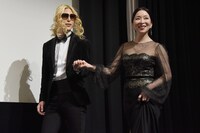 “出会って15分”のローランド（左）にエスコートされながら登壇した真矢ミキ（右）。