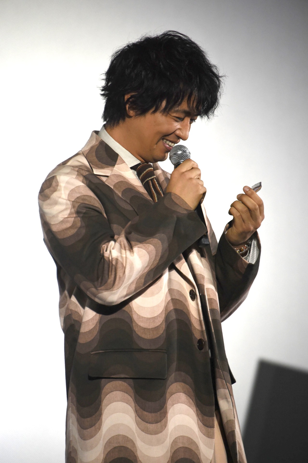来場者に配布されたクッキーを手にする斎藤工。