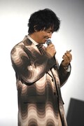 来場者に配布されたクッキーを手にする斎藤工。