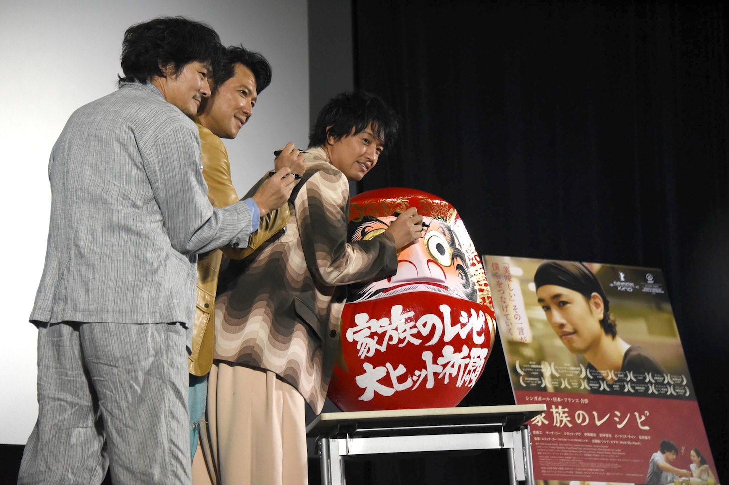 だるまと記念撮影する様子。