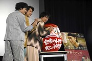 だるまと記念撮影する様子。