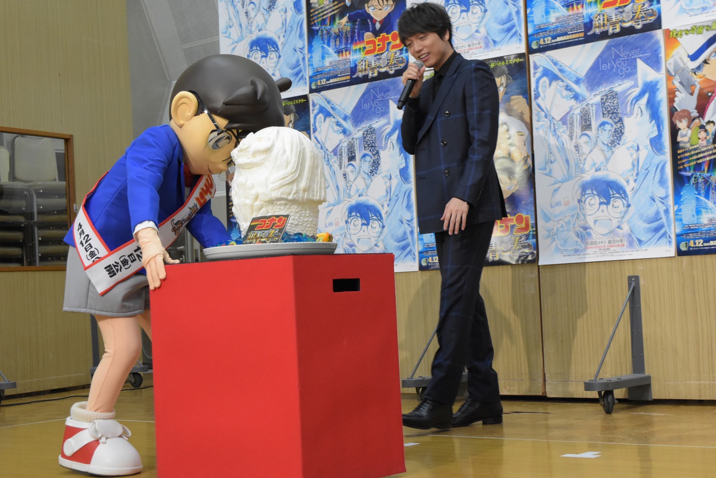 マーライオンのケーキを運ぶコナン。