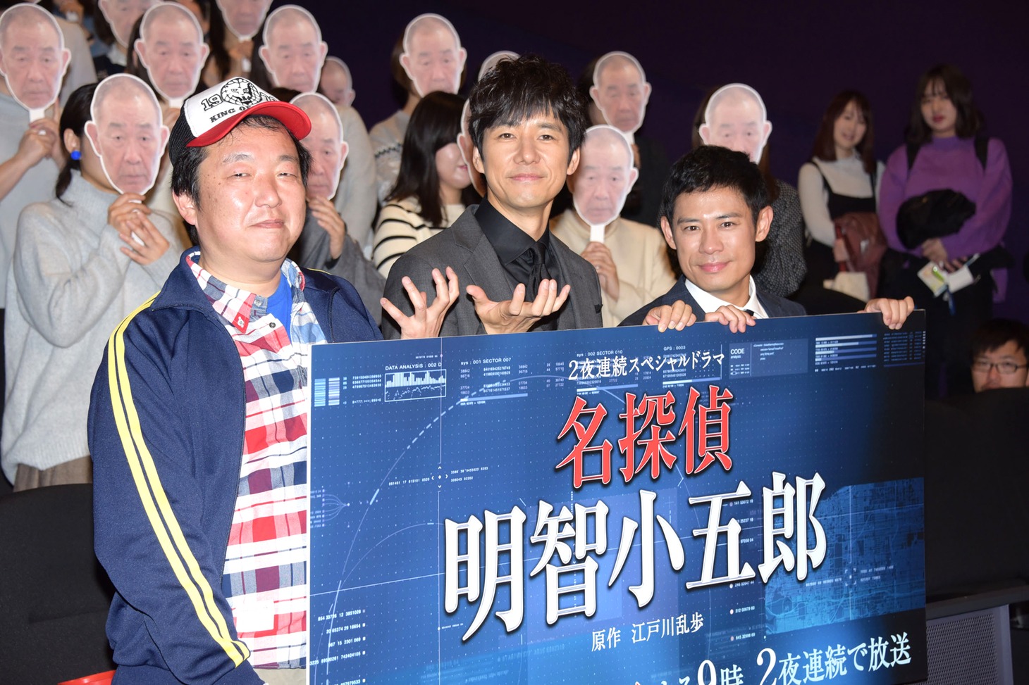 「名探偵・明智小五郎」完成披露試写会にて、でんでんのお面を持った観客と撮影する様子。左から木村ひさし、西島秀俊、伊藤淳史。