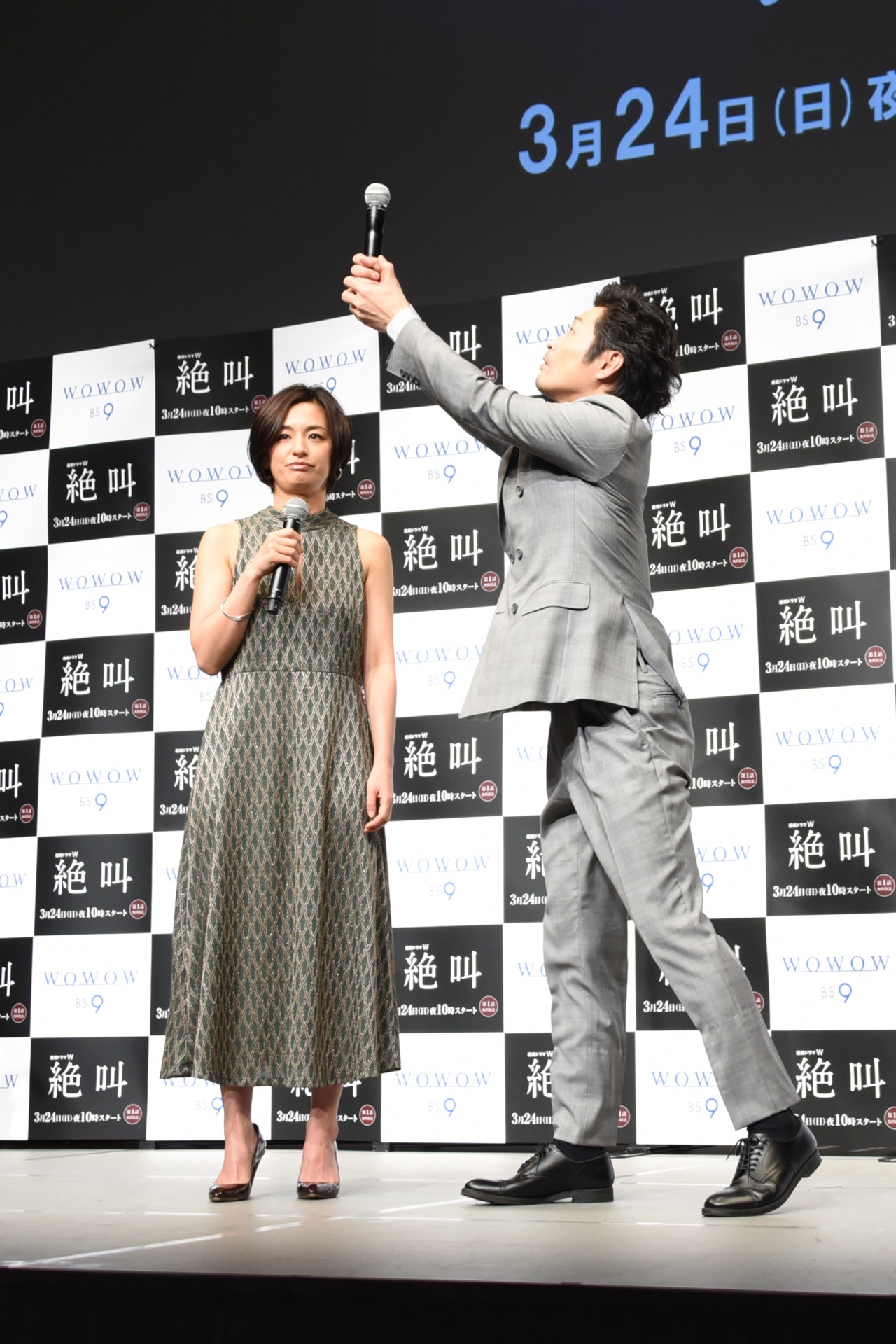 カラオケで尾野真千子（左）の代わりにマイクを持つ様子を再現する安田顕（右）。