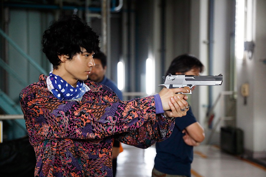 撮影の合間に、小道具の銃を構えて遊ぶ清原翔。