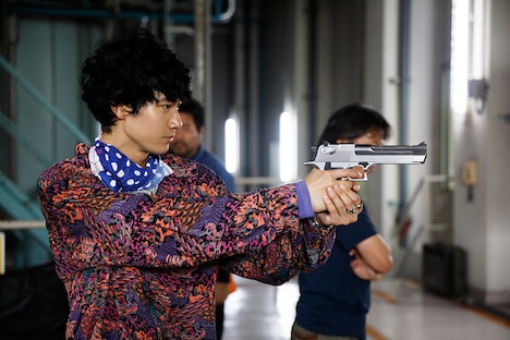 撮影の合間に、小道具の銃を構えて遊ぶ清原翔。