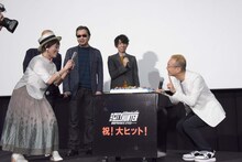 誕生日ケーキと神谷明を撮影をする伊倉一恵（左）。