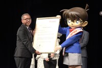 シンガポール政府観光局副長官のチャン・チーペイ（左）からウェルカムレターを贈呈されたコナン（右）。