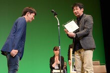 谷垣健治（左）から表彰される横山誠（右）。