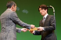 野呂慎治（左）から表彰される栗田政明（右）。