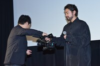 山田孝之（右）にカメラを渡す牧有太（左）。