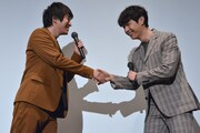 握手を交わす村井良大(左)とジュンQ(右)。