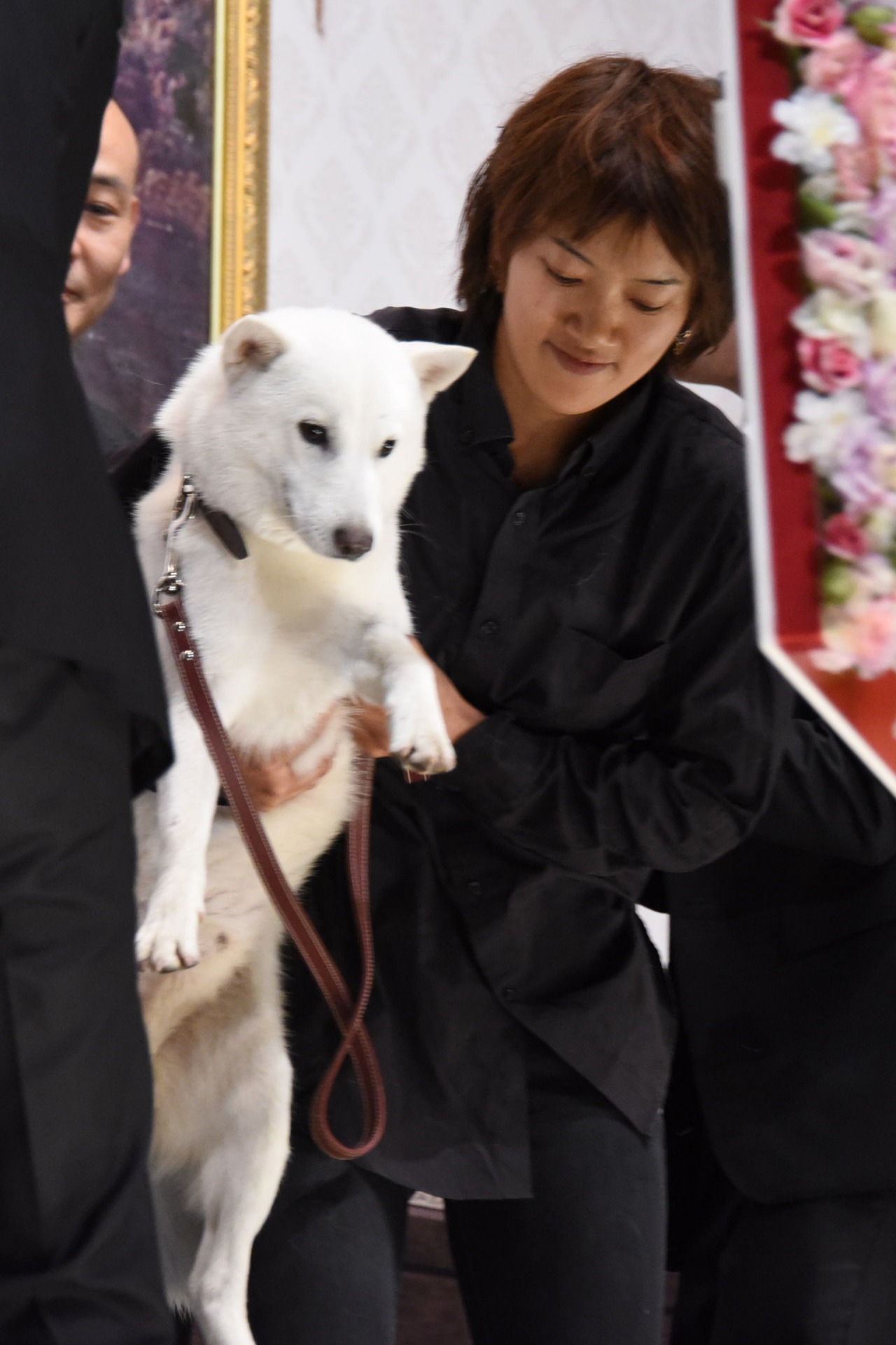 トレーナーに抱き上げられるカイル。