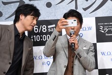 観客を撮ろうとする高橋克典（右）とスマホの画面をのぞき込む中村俊介（左）。