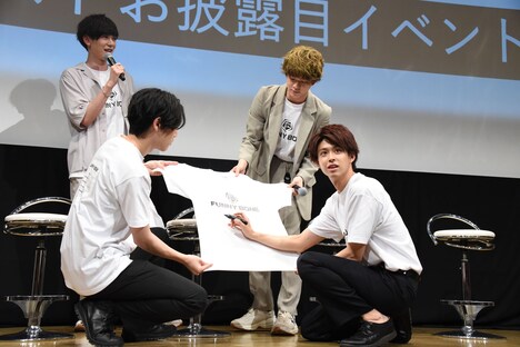 Tシャツにサインを書くキャストたち。