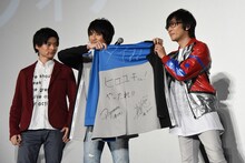 寺島拓篤（右）にパーカーを贈る小池亮介（中央）。