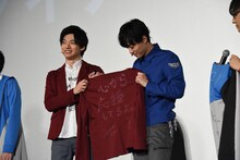井上祐貴（右）にジャケットを贈る平田雄也（左）。