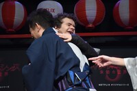 井戸田潤（手前）にハグされるゲイテン・マタラッツォ（奥）。