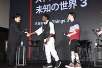 司会のジョン・カビラ（左）と握手するケイレブ・マクラフリン（中央）。