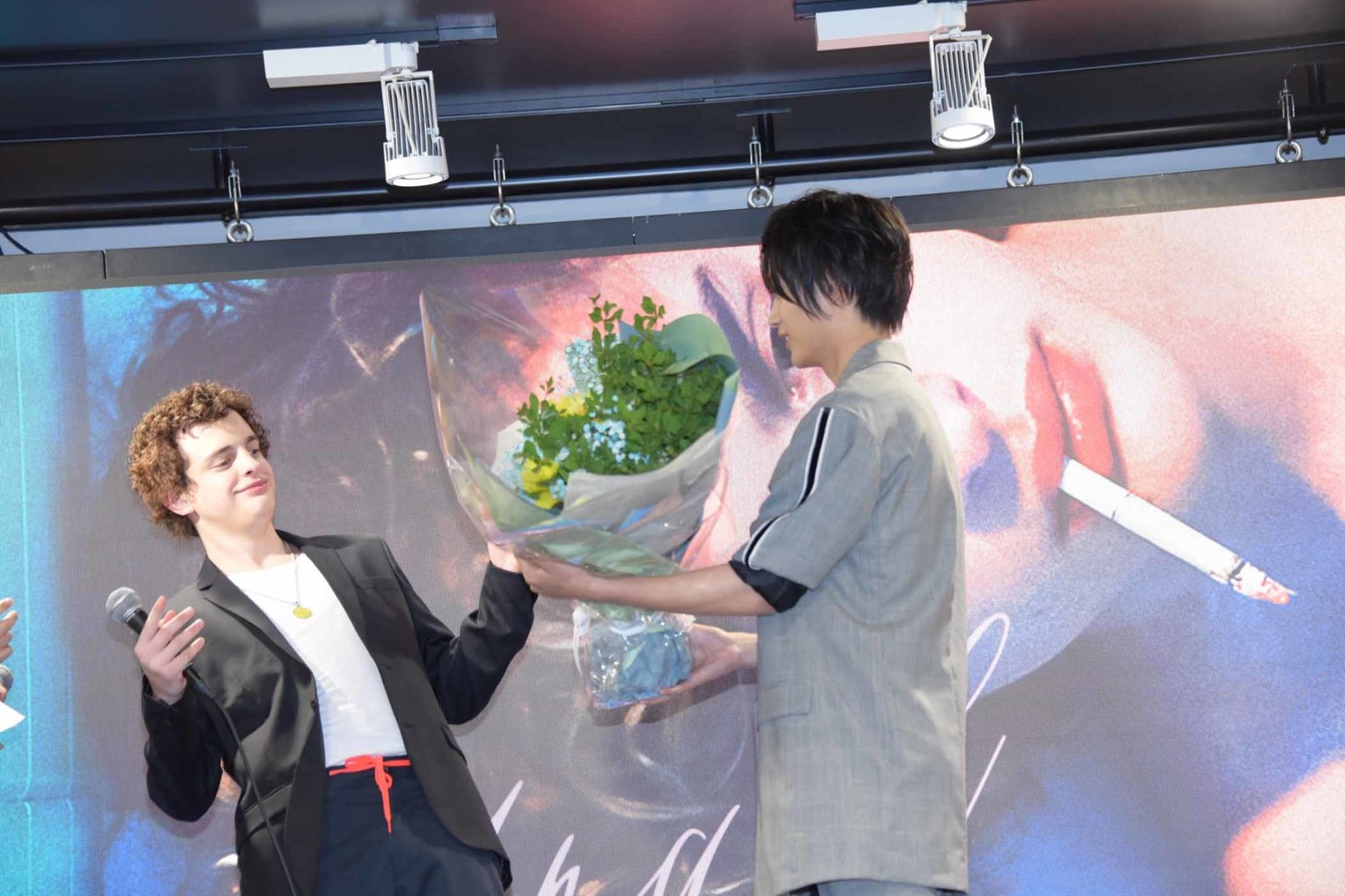 神尾楓珠（右）がロレンソ・フェロ（左）に花束を渡す様子。