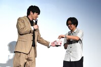 「まあ、ポップコーンでも食べなよ」と促す田中圭（左）。