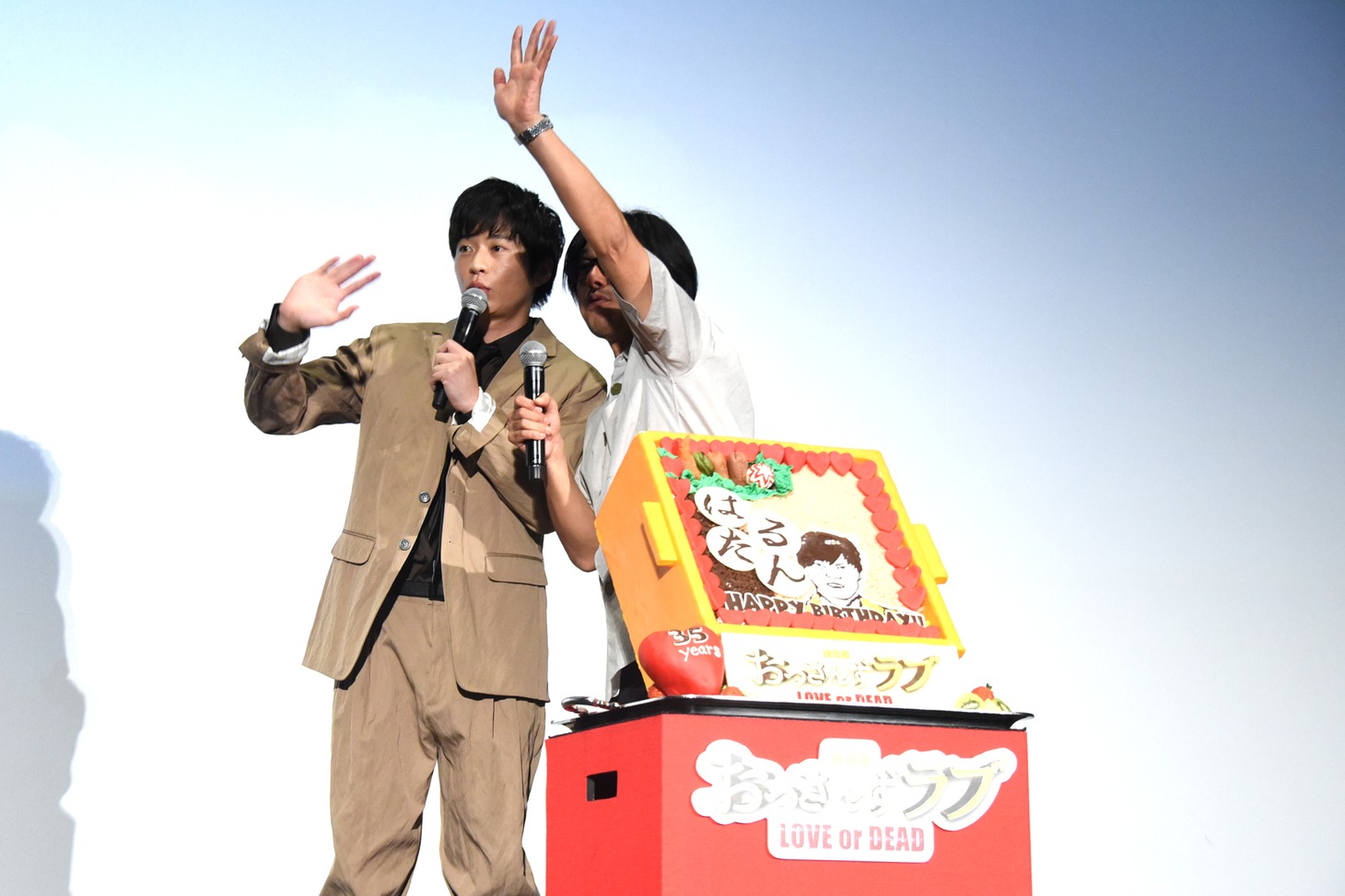 ライブビューイングカメラに手を振る田中圭（左）と瑠東東一郎（右）。
