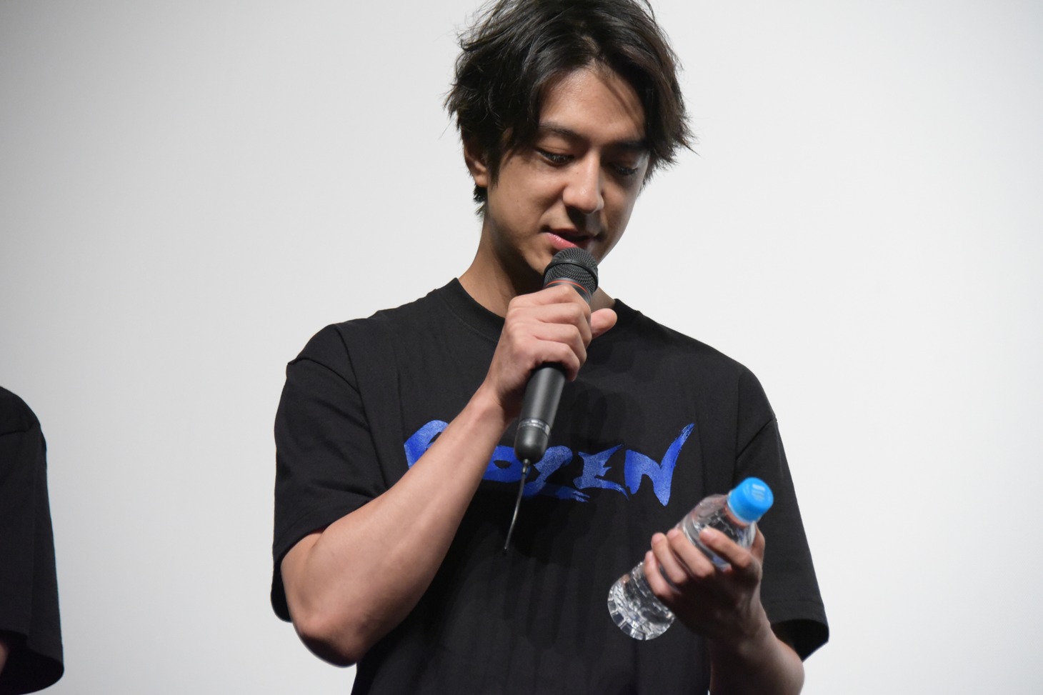 ステージ上にミネラルウォーターを持ってきてしまった松本寛也。