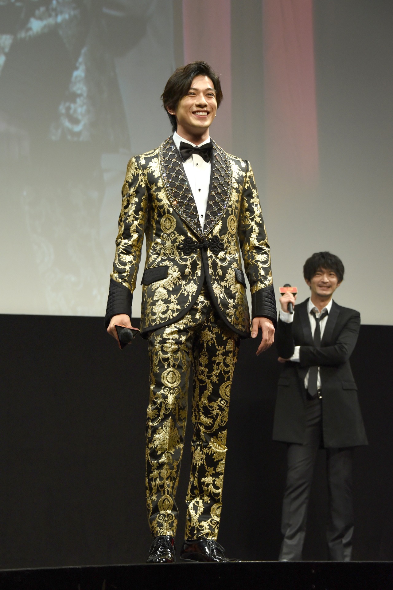 イベント登壇中に、自身の衣装の派手さに気付いた新田真剣佑。