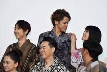 フォトセッション中、背が低いため宮野真守（後列中央）の肩につかまって背伸びをしていた沢城みゆき（後列右）。