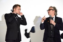 デクスター・フレッチャー（右）に褒められている間、耳をふさぐタロン・エジャトン（左）。