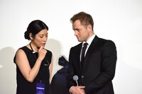 通訳の話に耳を傾けるタロン・エジャトン（右）。