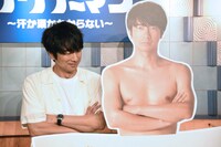 自分のパネルとの2ショット撮影に戸惑う眞島秀和（左）。