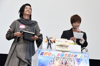 渡邊圭祐（左）のサインが入った自分の写真をプレゼントされ、戸惑う奥野壮（右）。