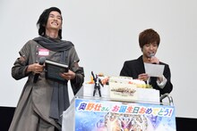 渡邊圭祐（左）のサインが入った自分の写真をプレゼントされ、戸惑う奥野壮（右）。