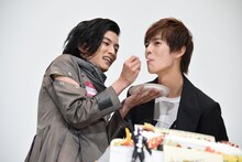 奥野壮（右）にケーキを食べさせる渡邊圭祐（左）。