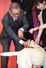 パルに飛びかかられた國村隼（左）。