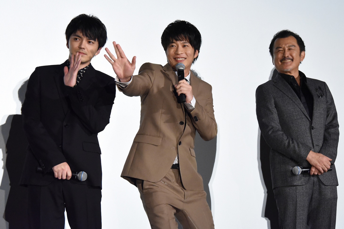 左から、中継カメラに挨拶する林遣都、田中圭、吉田鋼太郎。