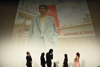 「楽園」出演者であり、第76回ヴェネツィア国際映画祭に参加した村上虹郎の写真を見る登壇者たち。