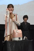 受話器を持つ飯豊まりえ（左）。