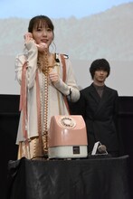 受話器を持つ飯豊まりえ（左）。