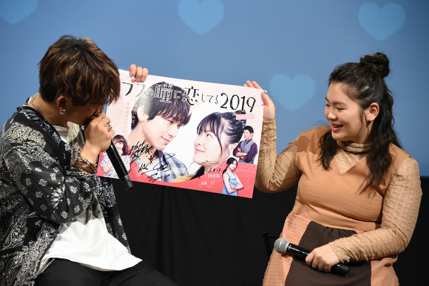 サイン入りポスターを紹介するNAOTO（左）と富田望生。