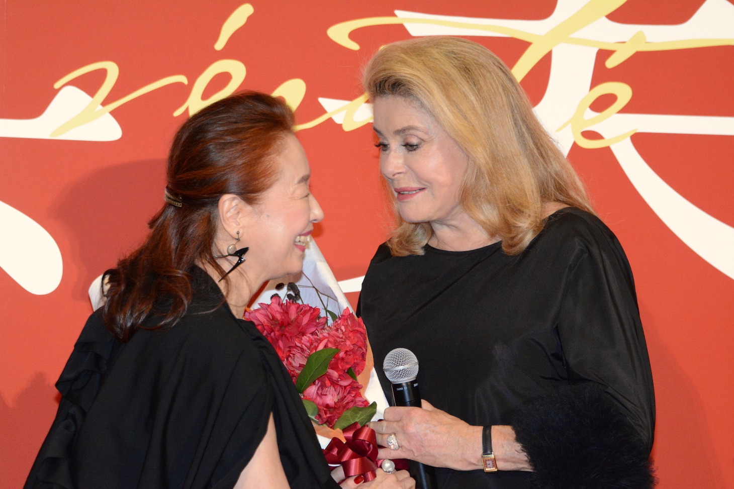 カトリーヌ・ドヌーヴ（右）に花束を渡す宮本信子（左）。
