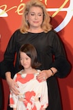 佐々木みゆ(手前)を自分のもとに引き寄せるカトリーヌ・ドヌーヴ(奥)。