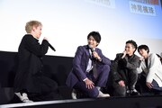 しゃがんだままそれぞれの写真について語り合う出演者たち。