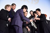 高橋のイラストを見ようと集まる登壇者たち。