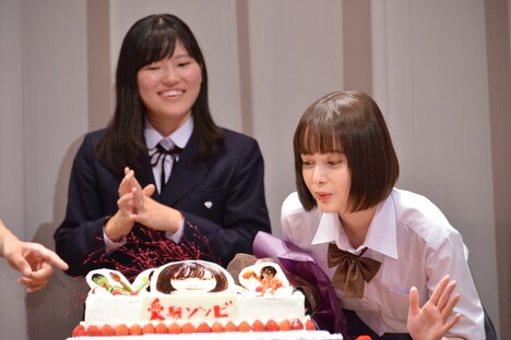 ケーキに顔を寄せる玉城ティナ（右）。