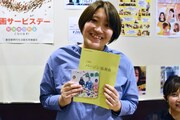 「バージン協奏曲 それゆけ純白パンツ！」の台本ノートと、主題歌CDをアピールする小栗はるひ。