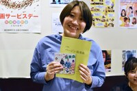 「バージン協奏曲 それゆけ純白パンツ！」の台本ノートと、主題歌CDをアピールする小栗はるひ。