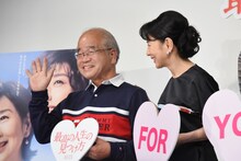 当選者の父にムービーカメラへ手を振ることを教える吉永小百合（右）。