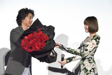 バラの花束を玉城ティナ（右）に手渡す伊藤健太郎（左）。